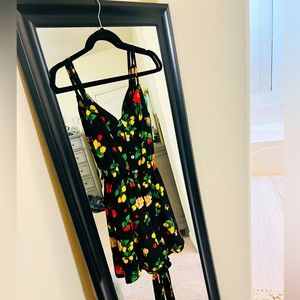 Romper, black with fruit, a tie in the back to cinch the waist.